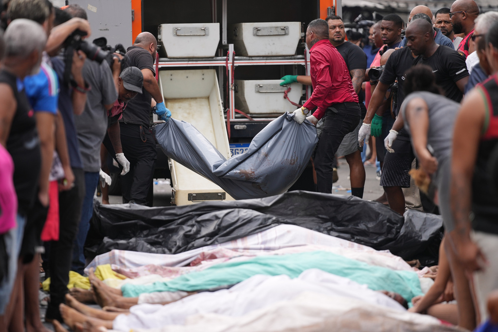 Forensic workers collect the bodies of people killed the day before during a police raid targeting the Comando Vermelho gang in the Complexo da Penha favela of Rio de Janeiro, Brazil, Wednesday, Oct. 29, 2025. (AP Photo/Silvia Izquierdo)