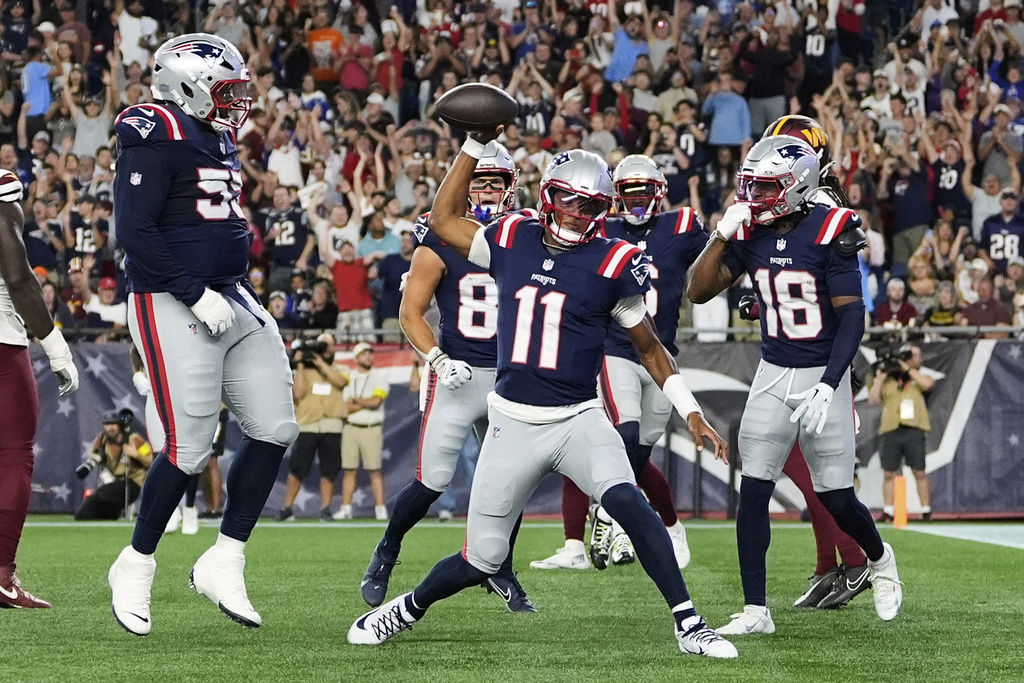 New England Patriots quarterback Joshua Dobbs (11) celebrates after a touchdown during the first half of an NFL preseason football game against the Washington Commanders Friday, Aug. 8, 2025, in Foxborough, Mass. (AP Photo/Charles Krupa)