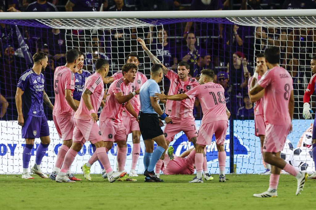Inter Miami players an surround official, center, while arguing about a corner kick against Orlando City during the first half of an MLS soccer match, Sunday, Aug. 10, 2025, in Orlando, Fla. (AP Photo/Kevin Kolczynski)