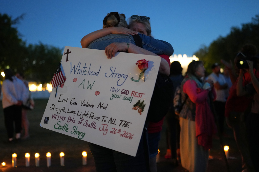Michelle Whitehead, right, and her sister Judy Whitehead, left, both cousin of victim Ashley Whitehead, during the vigil for victims the day after a shooting at Seattle Center during the Bite of Seattle food festival, Monday, July 27, 2026, in Seattle. (AP Photo/Lindsey Wasson)