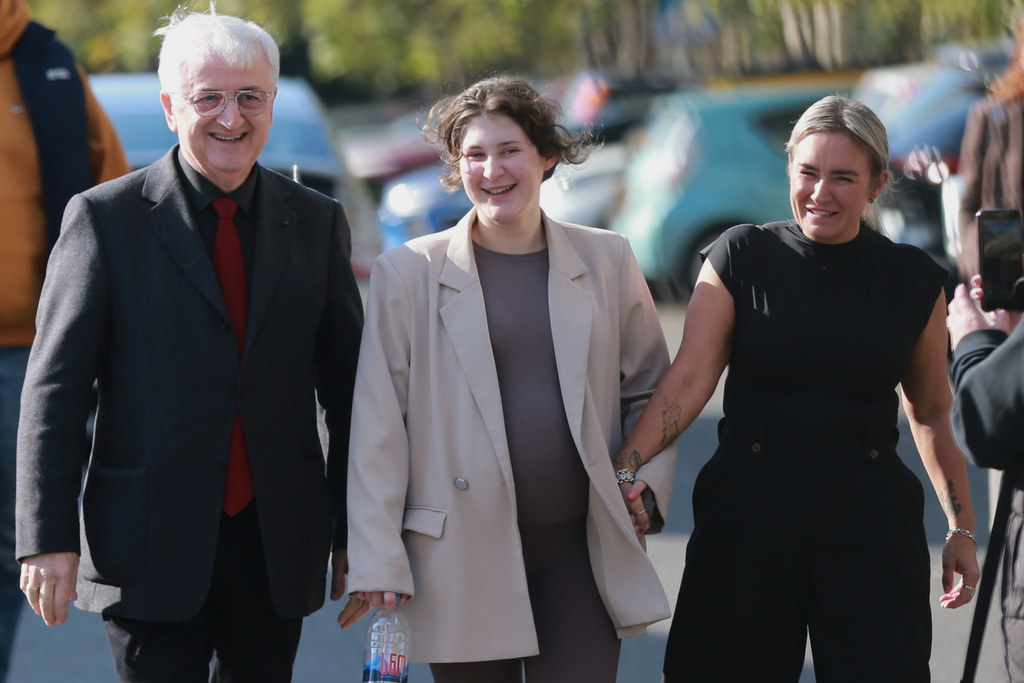 Bella May Culley, 19-year-old, who was arrested upon arrival at the Tbilisi Airport in May and accused of attempting to smuggle marijuana and hashish into the country, center, walks with her lawyer Malkhaz Salakaia, left, and her mother Lyanne Kennedy after she was released from prison near the court building, in Tbilisi, Georgia, on Monday, Nov. 3, 2025. (AP Photo/Zurab Tsertsvadze)
