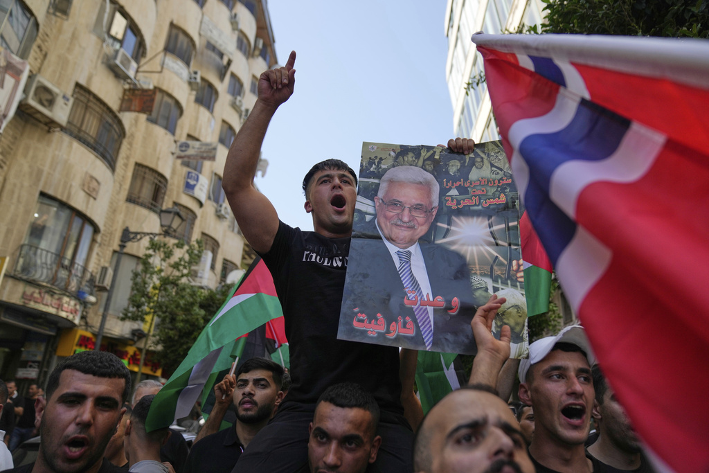 Palestinians chant national slogans and carry posters with pictures of President Mahmoud Abbas and read "you kept your promise," during a rally in support for Gaza and celebrating the latest western nations recognitions of the Palestinian state ahead of the United Nations General Assembly meetings, in the West Bank city of Ramallah Tuesday, Sept. 23, 2025. (AP Photo/Nasser Nasser)