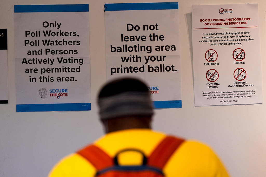 A man walks inside the The High Museum of Art voting center on the first day for early voting in Georgia, Tuesday, Oct. 13, 2026, in Atlanta. (AP Photo/Mike Stewart)