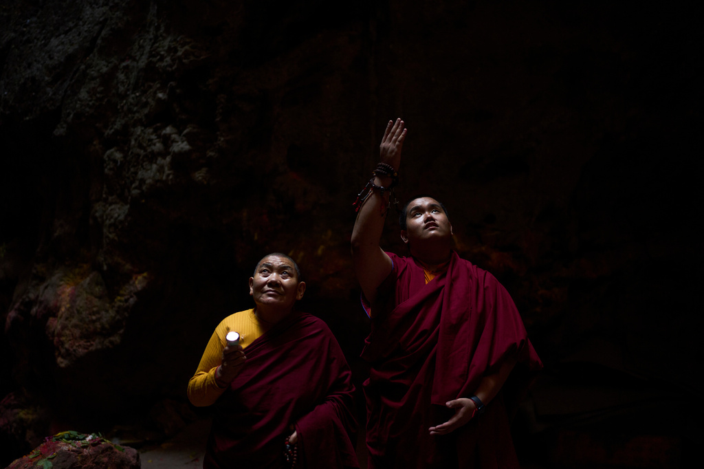 Jalue Dorje, right, looks at a painting inside Maratika Caves, in the Khotang District of eastern Nepal, Monday, April 13, 2026. (AP Photo/Niranjan Shrestha)