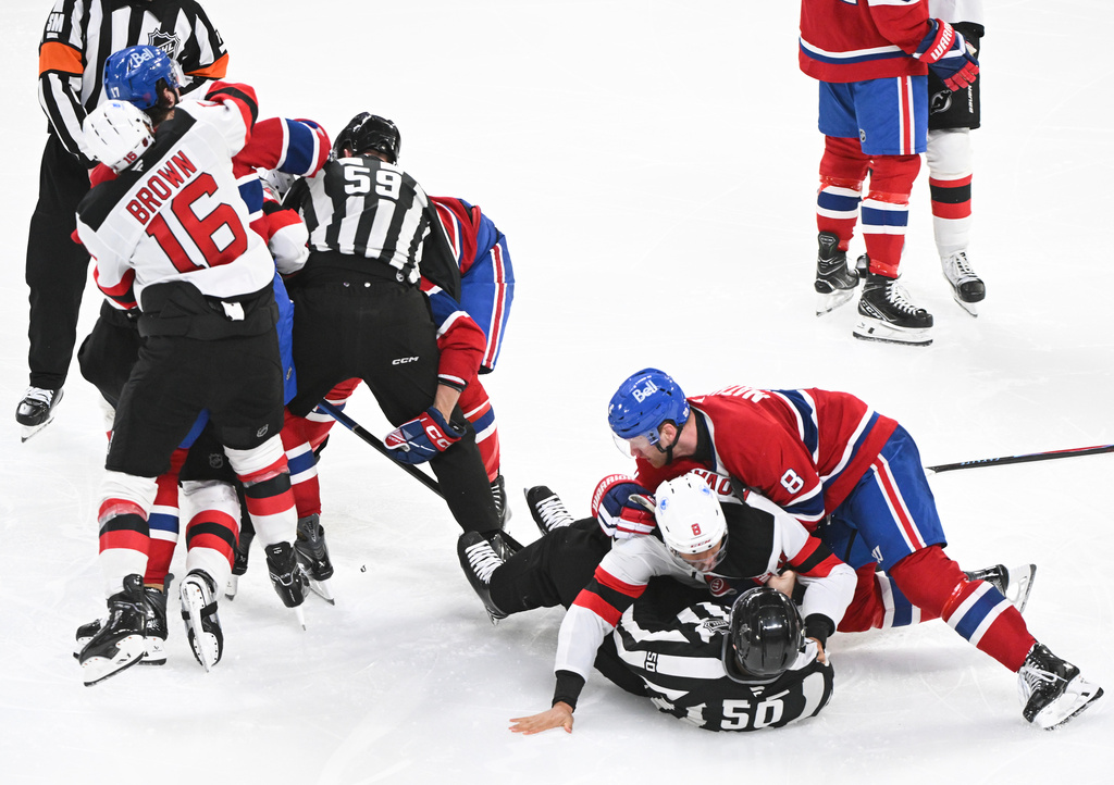 Players from the New Jersey Devils and Montreal Canadiens scuffle during the third period of an NHL hockey game in Montreal, Sunday, April 5, 2026. (Graham Hughes/The Canadian Press via AP)