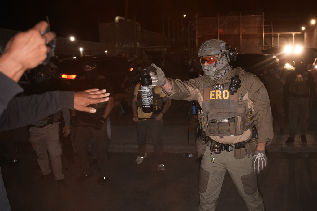A federal immigration officer aims an OC canister at protesters outside Delaney Hall detention center Thursday, May 28, 2026, in Newark, N.J. (AP Photo/Angelina Katsanis)