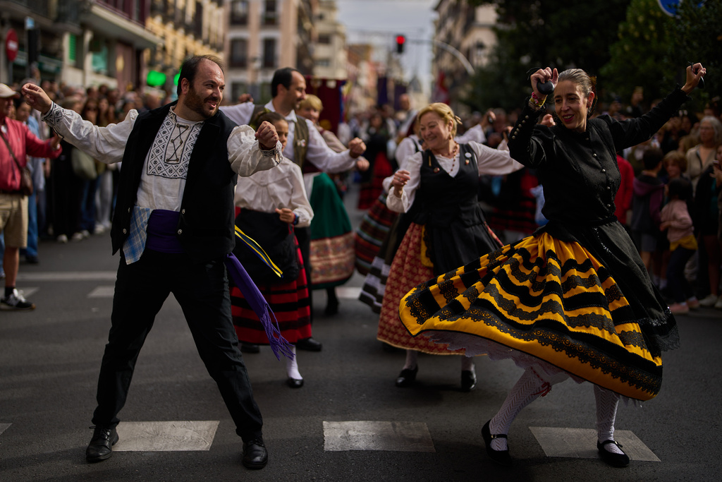 People in regional traditional costumes take part in the herding of sheep through central Madrid, Spain, as shepherds lead the animals through the streets in defense of ancient grazing and migration rights, Sunday, Oct. 19, 2025. (AP Photo/Manu Fernandez)