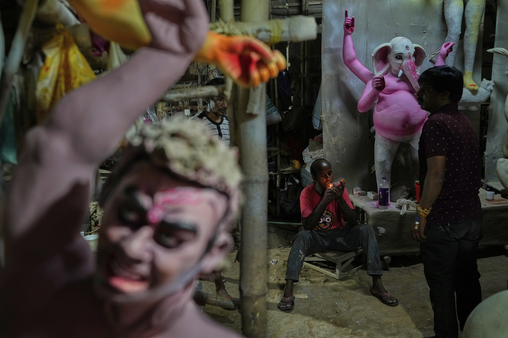Workers take a break while creating idols of Hindu deities ahead of the Durga Puja festival in New Delhi, India, Friday, Sept. 19, 2025. (AP Photo/Manish Swarup)