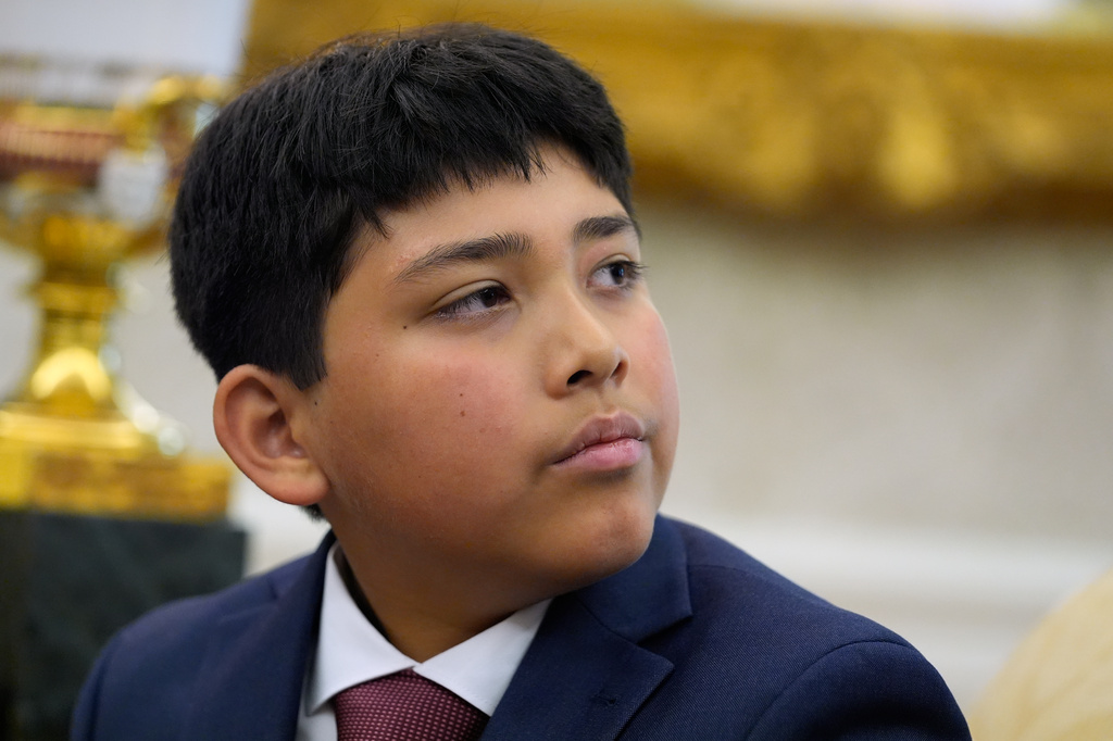 Nathaniel Rai listens as President Donald Trump meets with lifeguard Ryder Williams in the Oval Office of the White House, Monday, Aug. 17, 2026, in Washington. (AP Photo/Manuel Balce Ceneta)