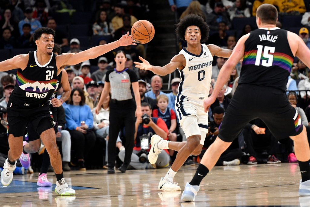 Denver Nuggets forward Spencer Jones (21) and Memphis Grizzlies forward Jaylen Wells (0) reach for the ball in the first half of an NBA basketball game, Monday, Nov. 24, 2025, in Memphis, Tenn. (AP Photo/Brandon Dill)