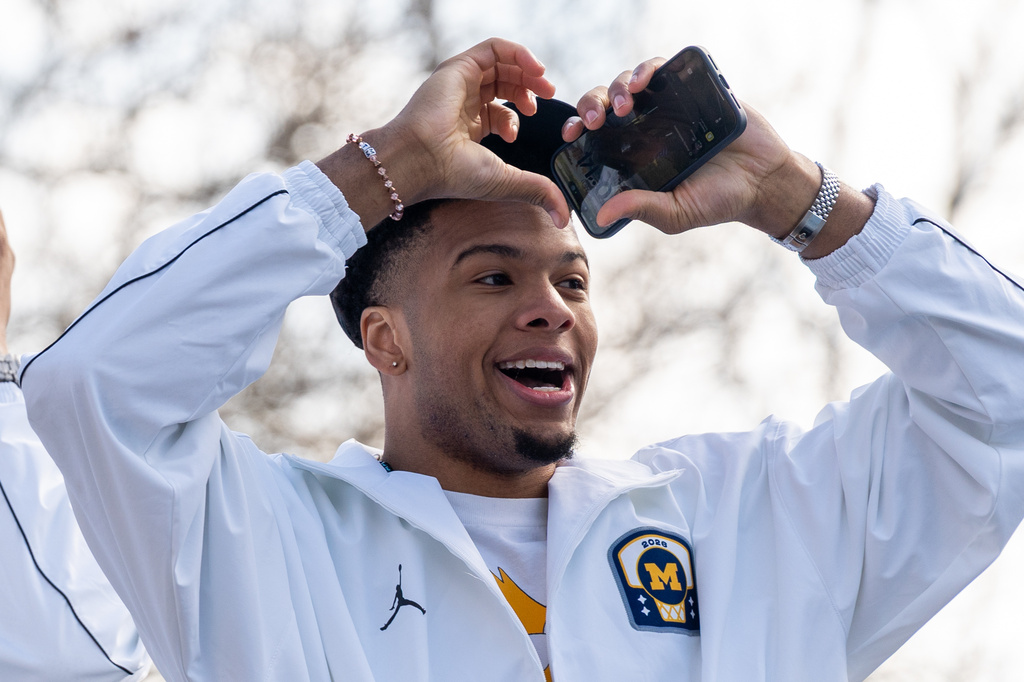 Michigan's Trey McKenney throws a heart sign to fans during a parade celebrating their national championship win in the NCAA college basketball tournament , Saturday, April 11, 2026, in Ann Arbor, Mich. (Devin Anderson-Torrez/Ann Arbor News via AP)