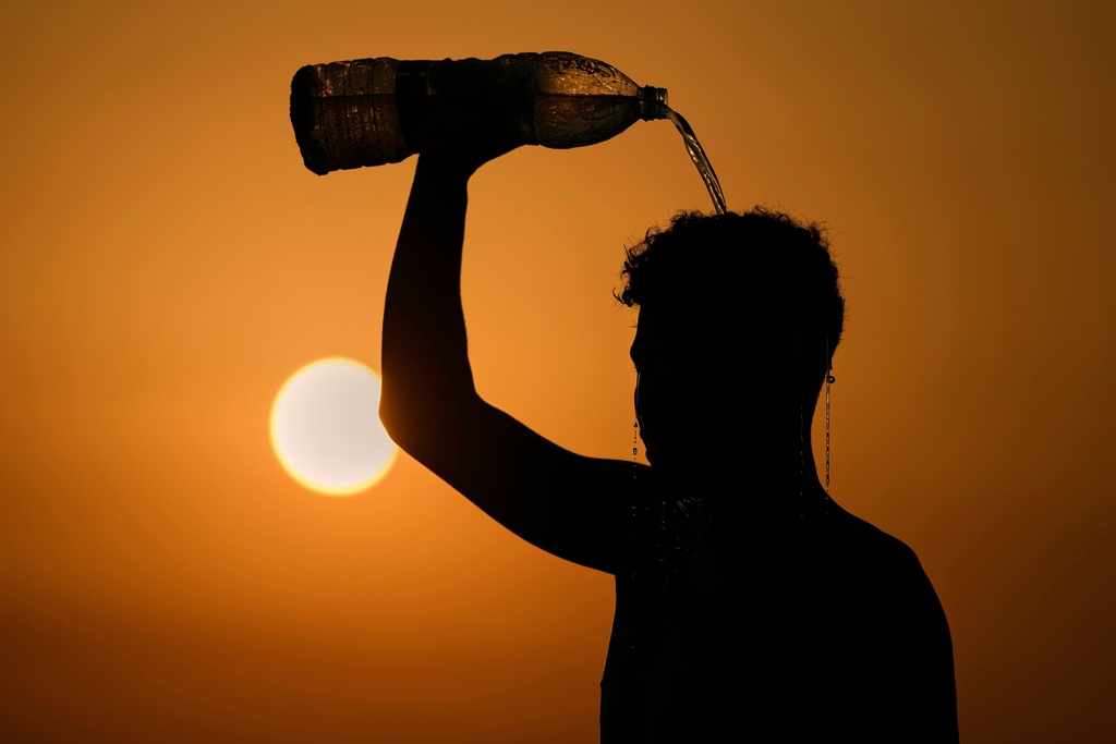 FILE - A man rinses with water after playing beach footvolley on the Ramlet al-Baida public beach in Beirut, Lebanon, Aug. 14, 2025, on a sweltering hot day. (AP Photo/Bilal Hussein, File)