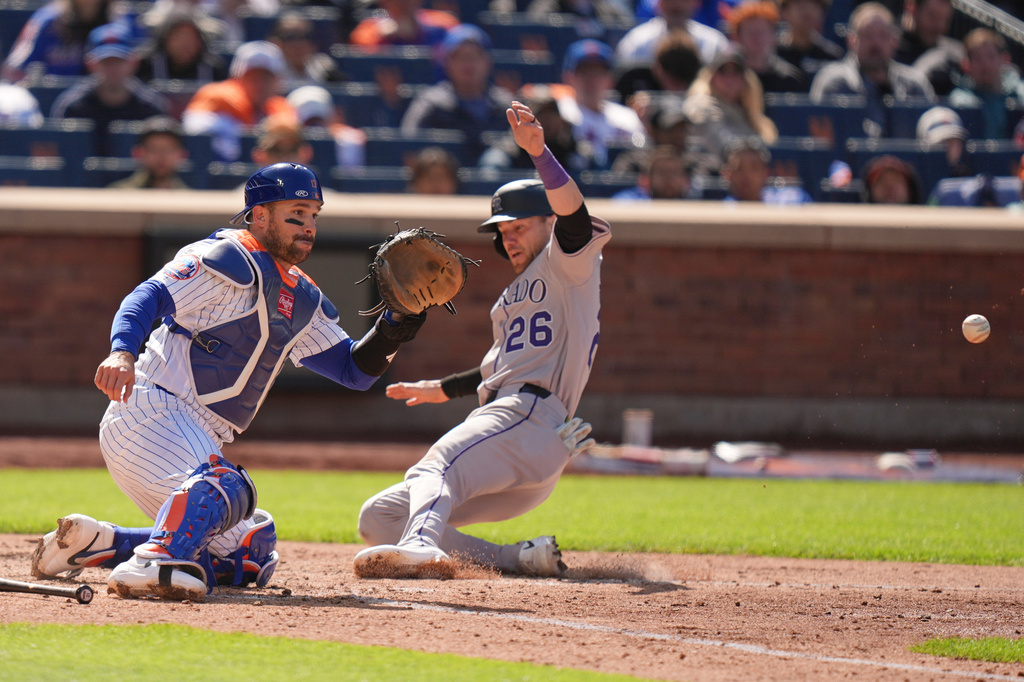 Colorado Rockies' Brett Sullivan (26), right, slides safely home while New York Mets catcher Luis Torrens waits for the ball during the seventh inning of the first baseball game of a doubleheader, Sunday, April 26, 2026, in New York. (AP Photo/Seth Wenig)