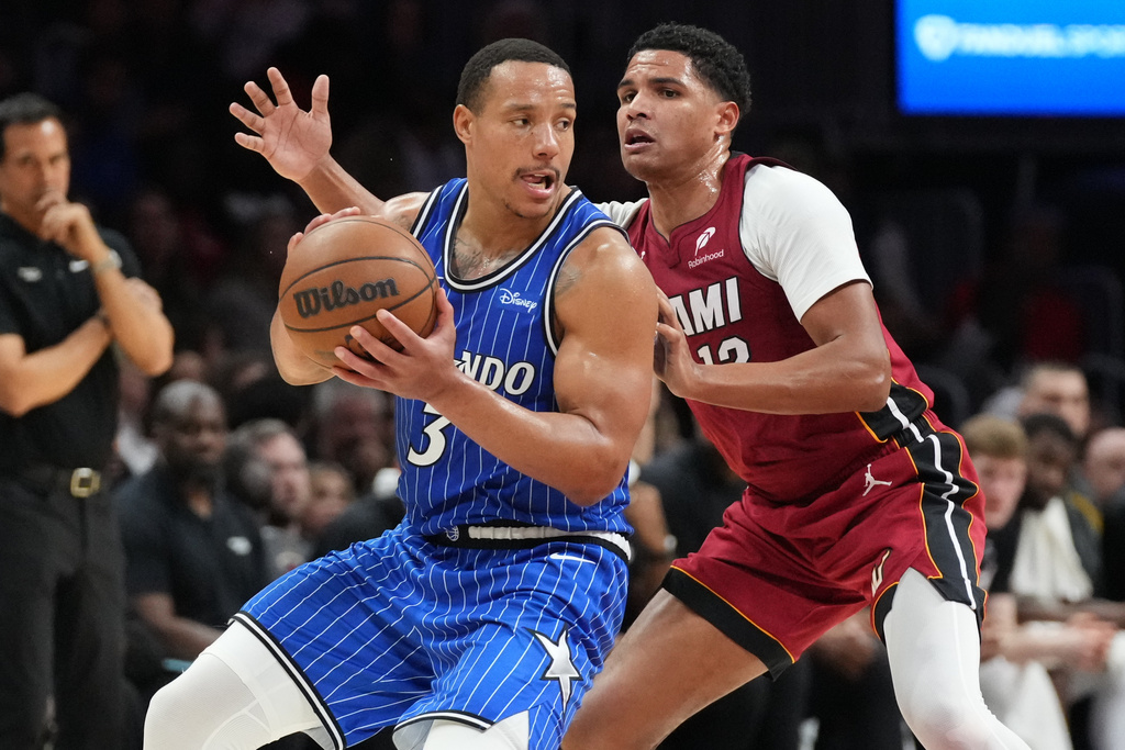 Orlando Magic guard Desmond Bane (3) looks to pass the ball as Miami Heat guard Dru Smith (12) defends during the second half of an NBA basketball game Wednesday, Jan. 28, 2026, in Miami. (AP Photo/Marta Lavandier)