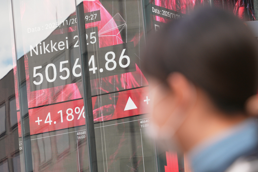 A person stands in front of an electronic stock board showing Japan's Nikkei index at a securities firm Thursday, Nov. 20, 2025, in Tokyo. (AP Photo/Eugene Hoshiko)