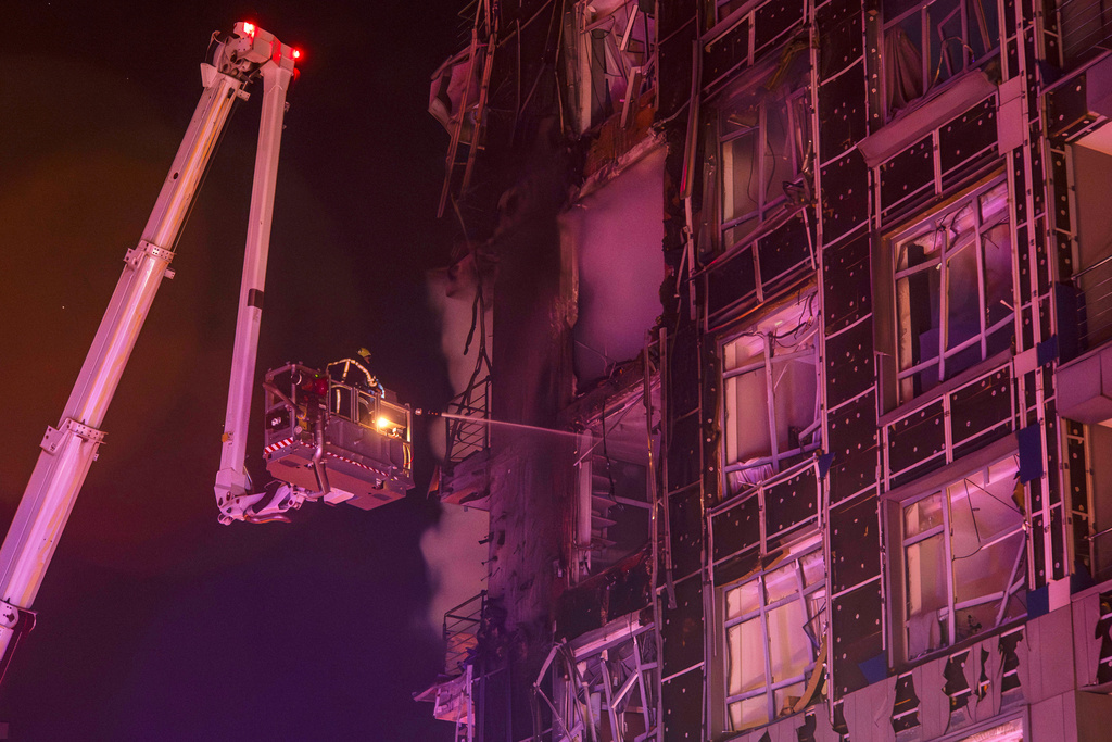 Emergency services personnel work to extinguish a fire following a Russian attack in Kyiv, Ukraine, Tuesday, Nov. 25, 2025. (AP Photo/Dan Bashakov)