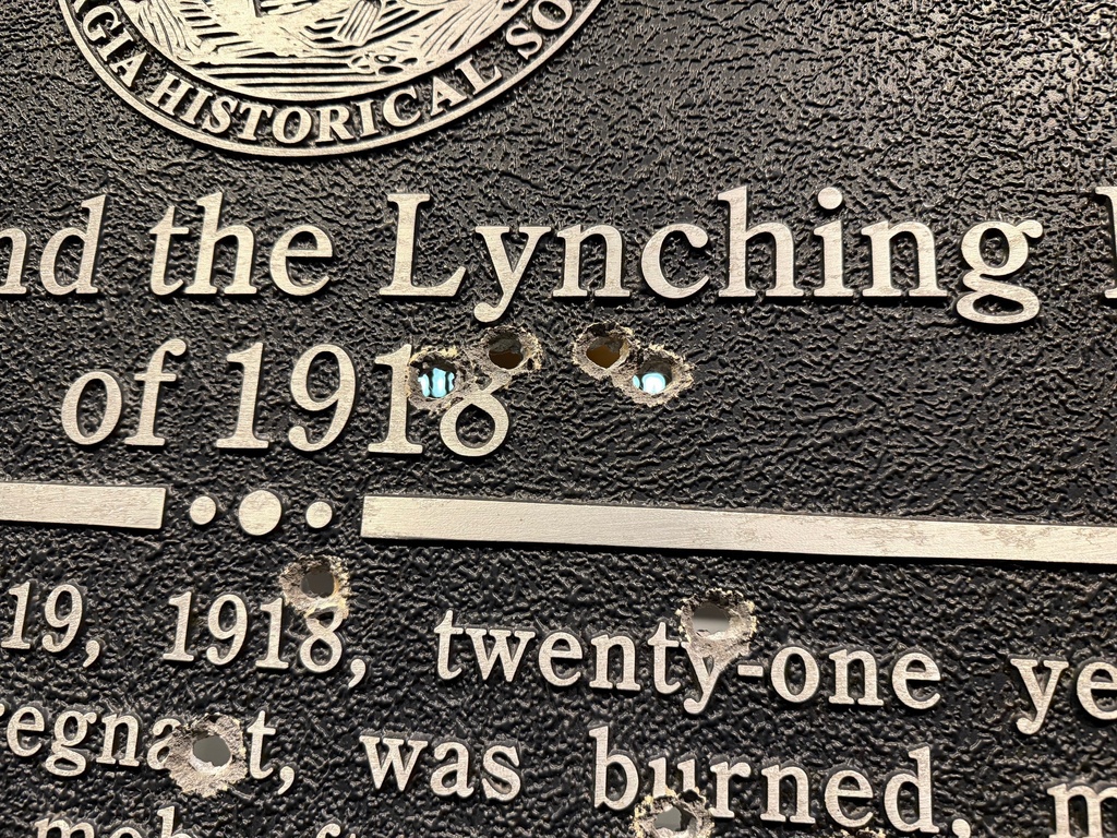 Closeup showing bullet holes in a Georgia Historic Marker memorializing the 1918 lynching of Mary Turner, now on display at the National Center for Civil and Human Rights, on Dec. 6, 2025 in Atlanta. (AP Photo/Michael Warren)