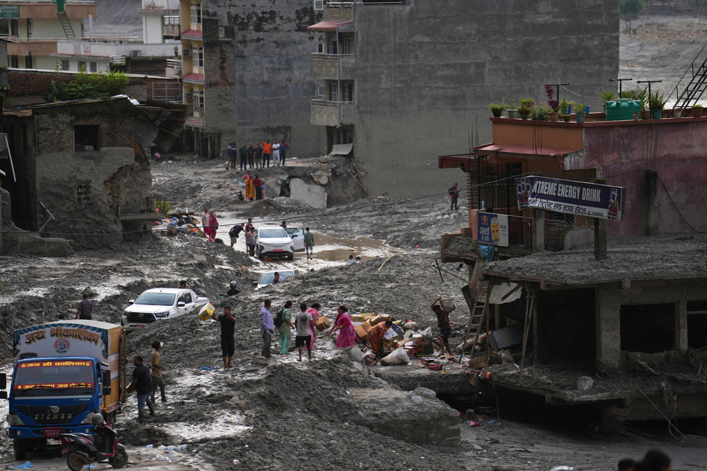 People salvage their belongings from a building damaged by flash flooding in Nuwakot district of Nepal, Tuesday, Sept. 1, 2026. (AP Photo/Rajesh Kumar Singh)