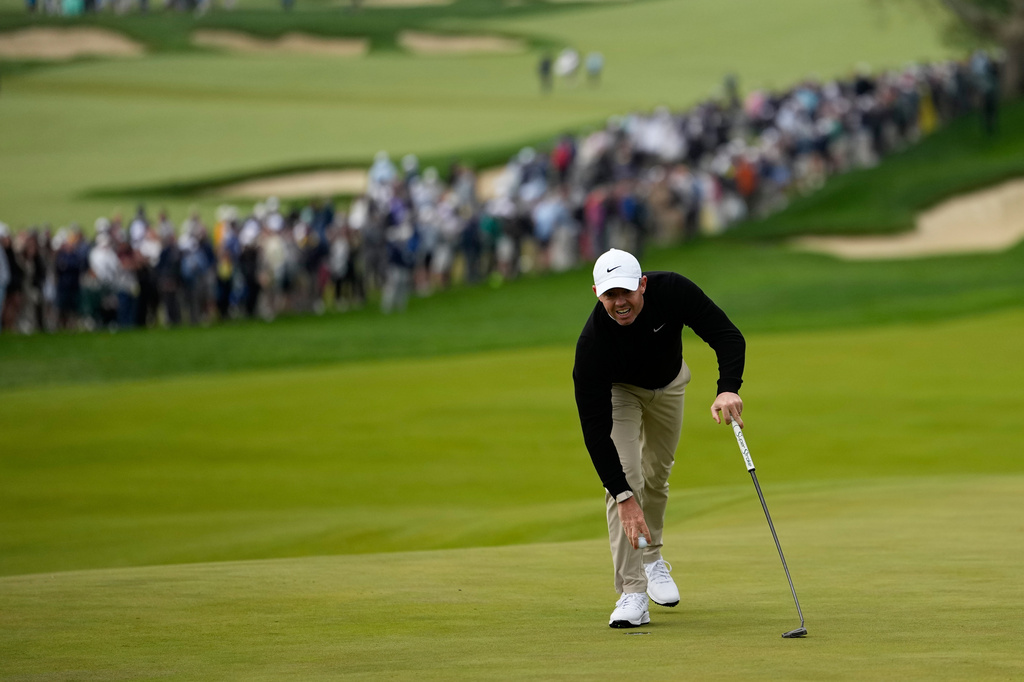 Rory McIlroy, of Northern Ireland, retrieves his ball from the hole on the 10th green during the first round of the PGA Championship golf tournament practice round at Aronimink Golf Club, Thursday, May 14, 2026, in Newtown Square, PA. (AP Photo/Carolyn Kaster)