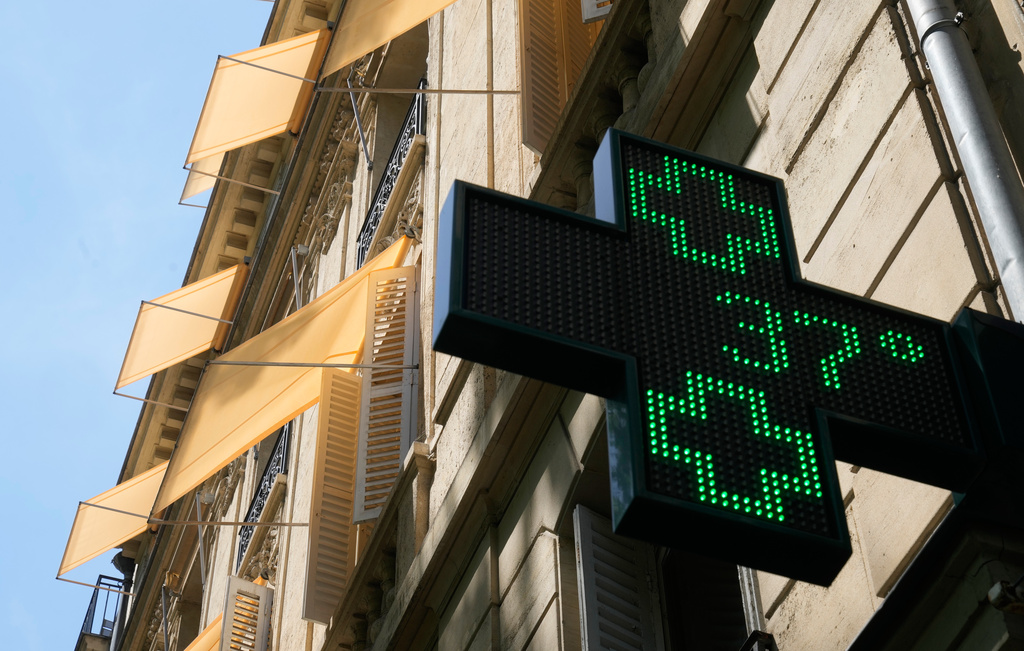 A sign outside a pharmacy displays a temperature of 37 degrees Celsius (98.6 degrees Fahrenheit) in Paris, Sunday, June 21, 2026. (AP Photo/Michel Euler)