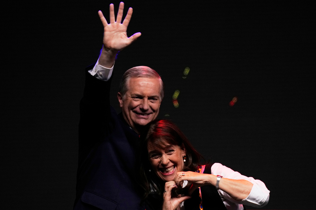 Presidential candidate Jose Antonio Kast of the Republican Party, accompanied by his wife Maria Pia Adriasola, waves to supporters after early results in the general elections in Santiago, Chile, Sunday, Nov. 16, 2025. (AP Photo/Esteban Felix)