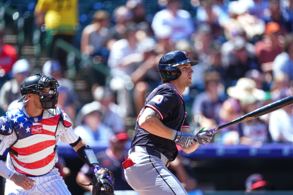 Cleveland Guardians' Chase DeLauter, right, watches his RBI triple with Colorado Rockies catcher Brett Sullivan, left, in the first inning of a baseball game Sunday, Aug. 23, 2026, in Denver. (AP Photo/David Zalubowski)