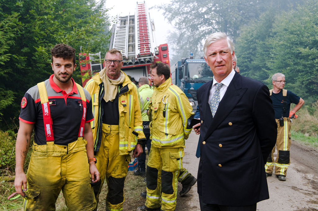 Belgium's King Philippe, right, meets firefighters as a wildfire burns in Waimes, Belgium, Monday, Aug. 17, 2026. (Nicolas Lambert, Pool Photo via AP)