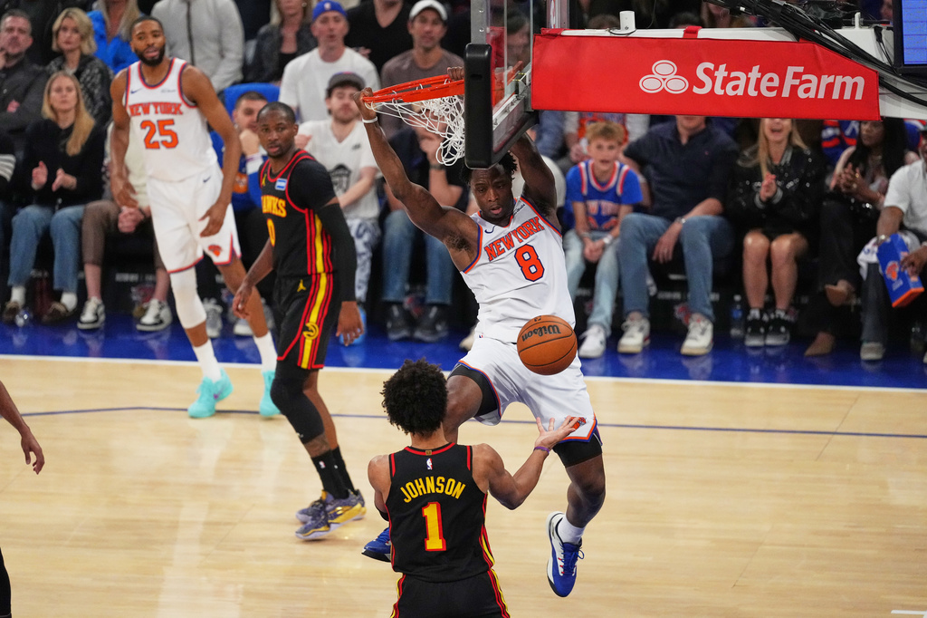 New York Knicks' Og Anunoby (8) dunks the ball in front of Atlanta Hawks' Jalen Johnson (1) during the first half in Game 1 of a first-round NBA playoffs basketball series, Saturday, April 18, 2026, in New York. (AP Photo/Frank Franklin II)