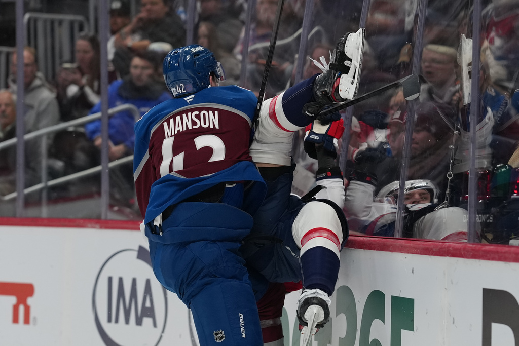 Colorado Avalanche defenseman Josh Manson, left, delivers a hrd check to Washington Capitals defenseman Martin Fehérváry in the second period of an NHL hockey game Monday, Jan. 19, 2026, in Denver. (AP Photo/David Zalubowski)