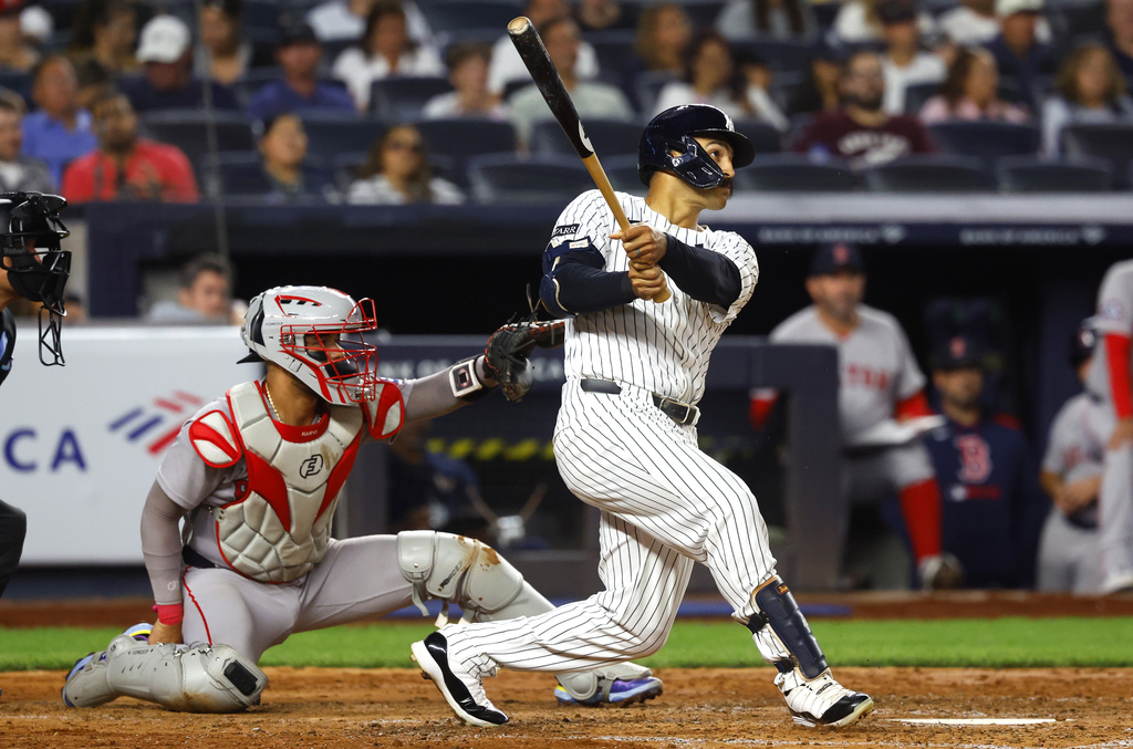 New York Yankees' Trent Grisham, right, follows through on a home run during the fifth inning of a baseball game against the Boston Red Sox, Sunday, Aug. 24, 2025, in New York. (AP Photo/Noah K. Murray)