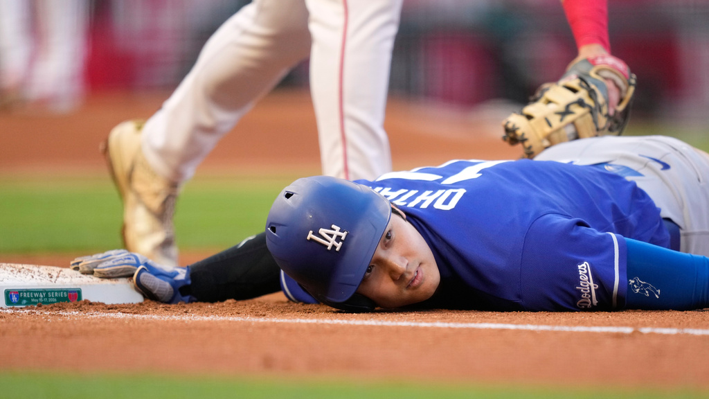 Los Angeles Dodgers' Shohei Ohtani, below, dives back to first under the tag of Los Angeles Angels first baseman Nolan Schanuel during the third inning of a baseball game Saturday, May 16, 2026, in Anaheim, Calif. (AP Photo/Mark J. Terrill)