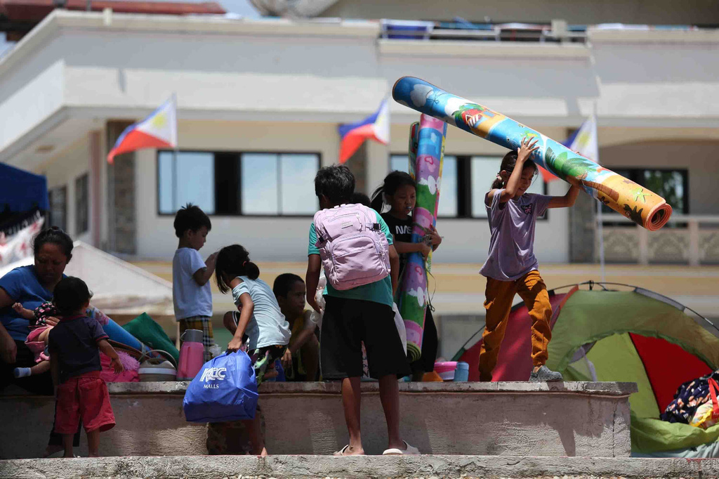 Residents take shelter in a field at a municipal hall in Sarangani province, Philippines, Wednesday, June 10, 2026. (AP Photo/Basilio Sepe)