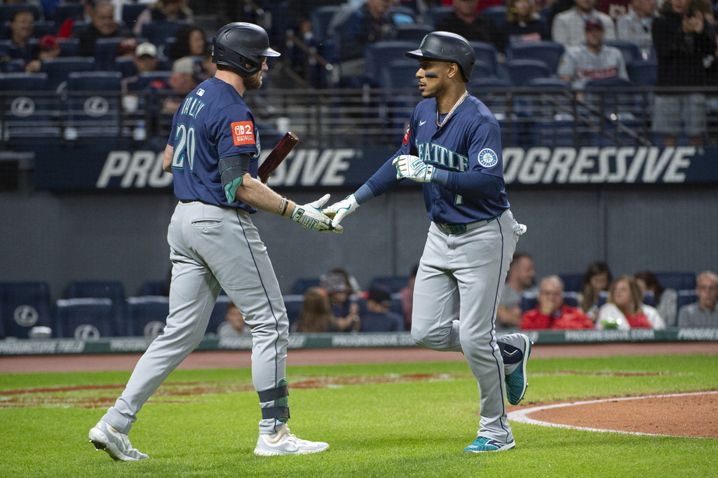 Seattle Mariners' Luke Raley, left, congratulates Jorge Polanco, right, after his solo home run off Cleveland Guardians starting pitcher Gavin Williams during the seventh inning of a baseball game, Saturday, Aug. 30, 2025, in Cleveland. (AP Photo/Phil Long)