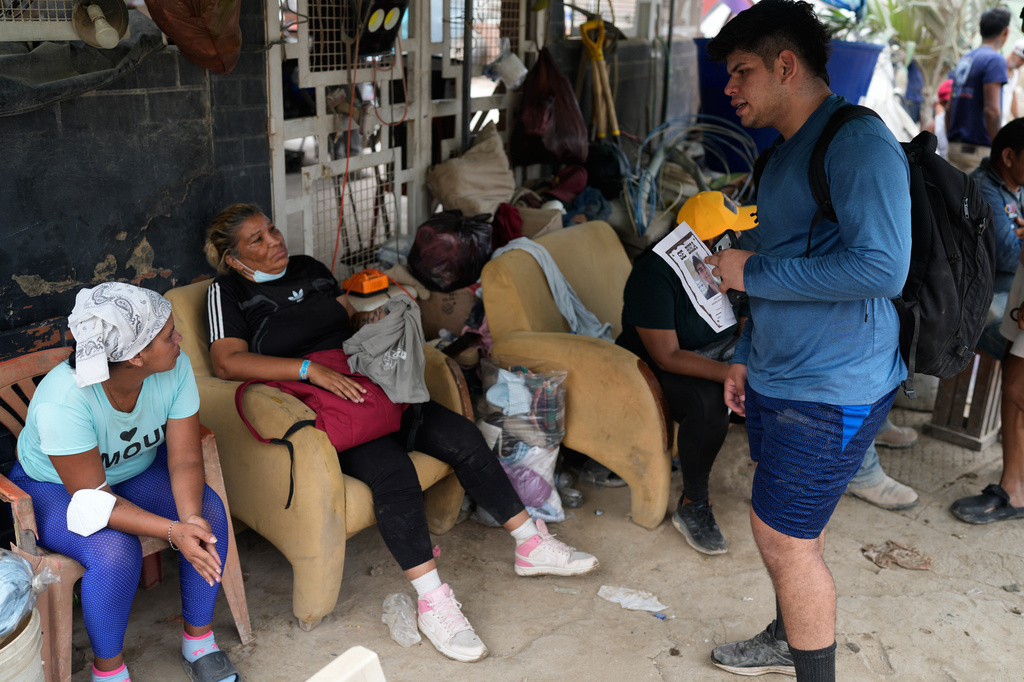Pedro Gomez asks people about his cousin, Andres Molina, who has been missing since the earthquakes, in La Guaira, Venezuela, Saturday, Aug. 22, 2026. (AP Photo/Ariana Cubillos)