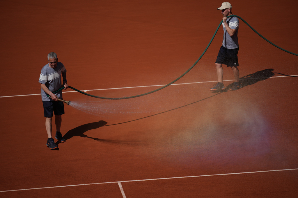 Stadium workers spray the court with water during the first round women's singles tennis match between Coco Gauff of the U.S. and Taylor Townsend of the U.S. at the French Open tennis tournament in Paris, Tuesday, May 26, 2026. (AP Photo/Christophe Ena)