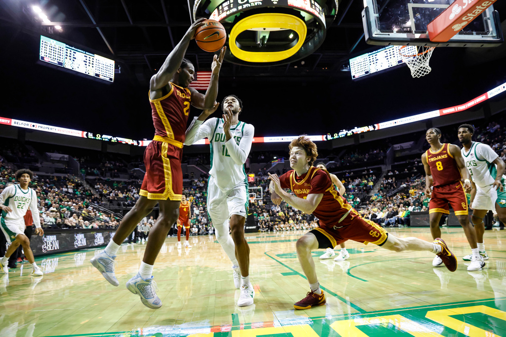 Southern California forward Ezra Ausar (2) pulls down a rebound against Oregon in the second half of an NCAA college basketball game in Eugene, Ore., Tuesday, Dec. 2, 2025. (AP Photo/Thomas Boyd)