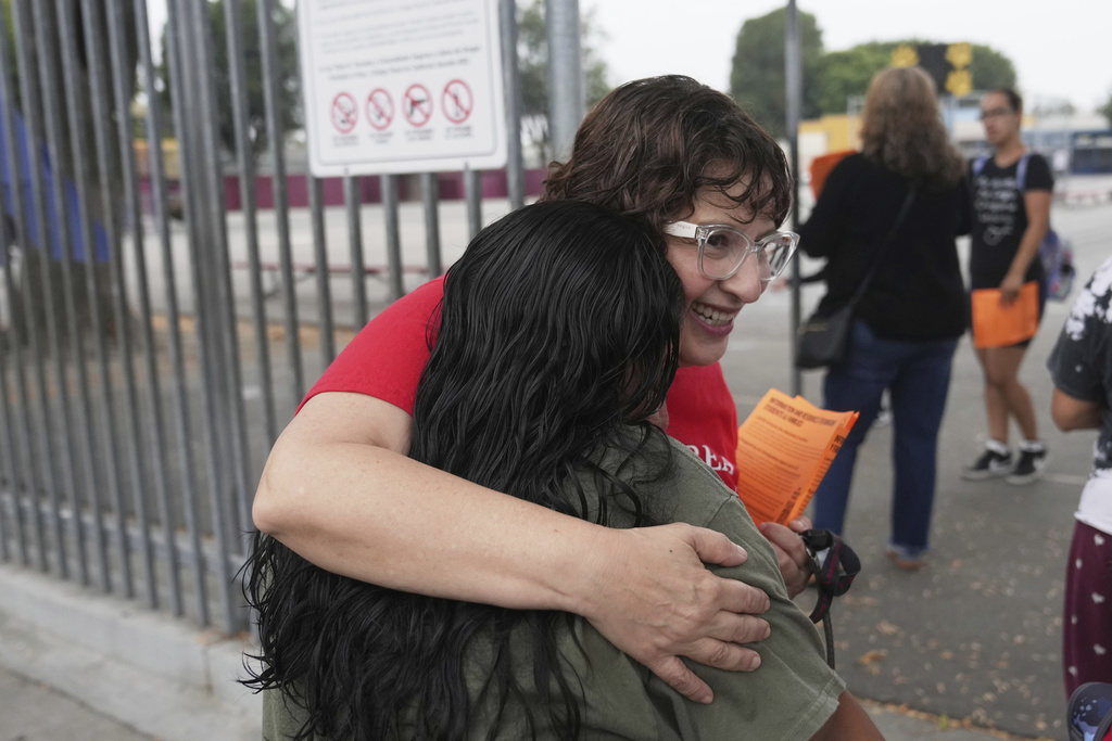 Teacher Ingrid Villeda embraces a parent on the first day of school Thursday, Aug. 14, 2025, in Los Angeles. (AP Photo/Marcio Jose Sanchez)
