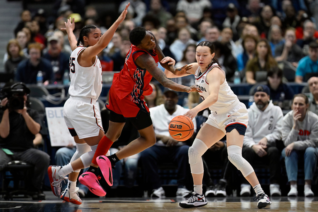UConn guard Kayleigh Heckel, right, steals the ball from St. John's guard Beautiful Waheed, center, as UConn guard Azzi Fudd, left, defends in the first half of an NCAA college basketball game, Wednesday, Jan. 7, 2026, in Hartford, Conn. (AP Photo/Jessica Hill)