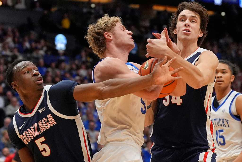 Gonzaga forward Emmanuel Innocenti (5) and forward Braden Huff (34) battle Kentucky guard Collin Chandler, center, for the ball during the first half of an NCAA college basketball game Friday, Dec. 5, 2025, in Nashville, Tenn. (AP Photo/George Walker IV)