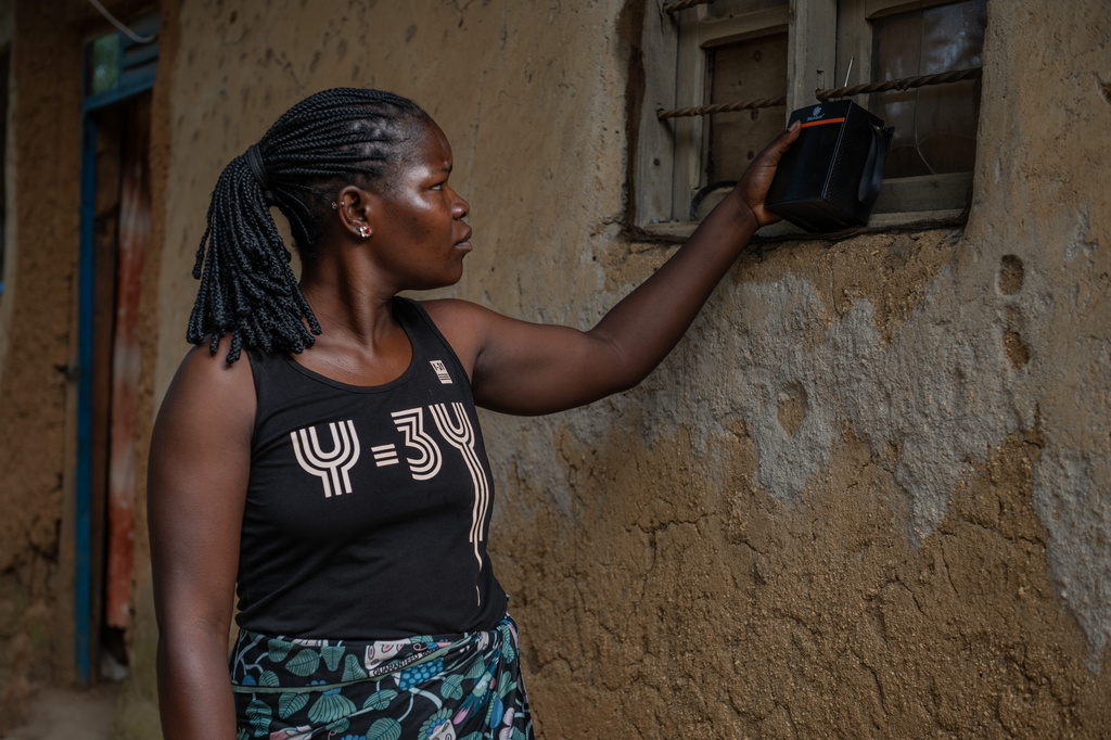 Chantie Joe Kiss, 31, listens to the radio for awareness and updates on Ebola in Bunia, Congo, Thursday, June 4, 2026. (AP Photo/Moses Sawasawa)