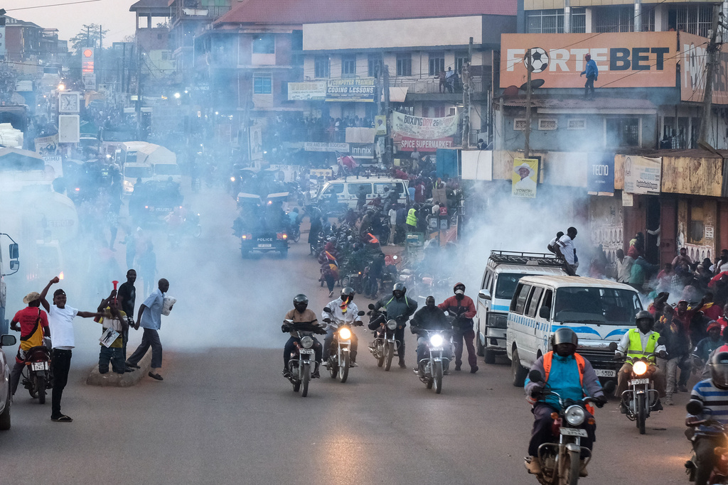 Supporters of Ugandan opposition presidential candidate Robert Kyagulanyi Ssentamu, who is known as Bobi Wine are tear-gassed by police during a campaign rally ahead of elections, in Mukono, Uganda, Friday, Jan. 9, 2026. (AP Photo/Hajarah Nalwadda)