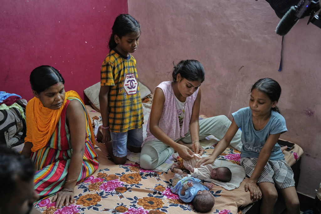Antima Kumari, center, trained in Care Companion Program (CCP), takes care of her nephews as her sister Lilawati watches in their house in Gurugram, a satellite city of New Delhi, India, on Aug. 8, 2025. (AP Photo/Manish Swarup)