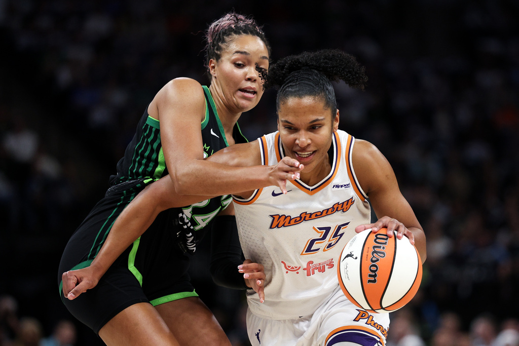 Phoenix Mercury forward Alyssa Thomas, right, drives toward the basket as Minnesota Lynx forward Napheesa Collier defends during the first half of Game 2 of a WNBA basketball playoff semifinals series Tuesday, Sept. 23, 2025, in Minneapolis. (AP Photo/Matt Krohn)