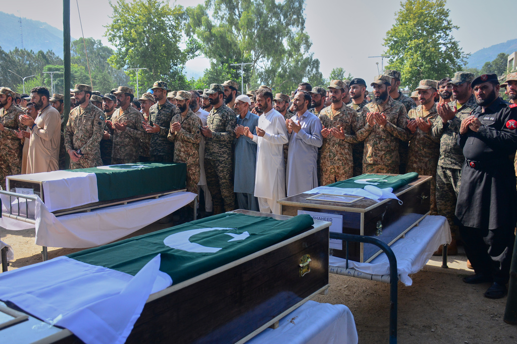 Military officers and civilians attend the funeral prayers of military personnel, killed in Wednesday's helicopter crash, during a funeral prayer, in Muzaffarabad, the capital of Pakistan-administered Kashmir, Thursday, June 11, 2026. (AP Photo/M.D. Mughal)