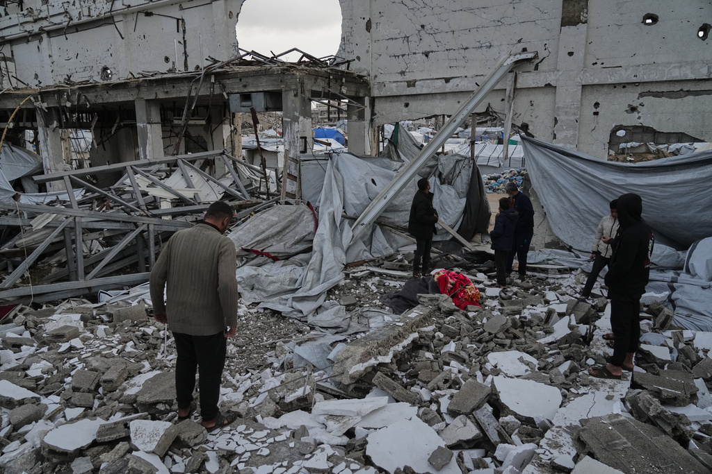 People inspect the site where at least four Palestinians died following the collapse of walls onto tents sheltering displaced people in Gaza City amid rainfall and strong winds, Tuesday, Jan. 13, 2026. (AP Photo/Jehad Alshrafi)
