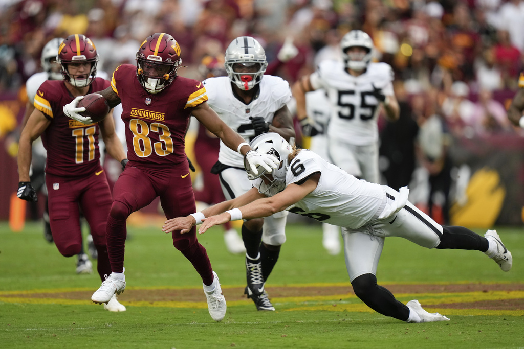 Las Vegas Raiders punter AJ Cole (6) tries to stop Washington Commanders wide receiver Jaylin Lane (83) as he runs for a touchdown during the second half of NFL football game Sunday, Sept. 21, 2025, in Landover, Md. (AP Photo/Stephanie Scarbrough)