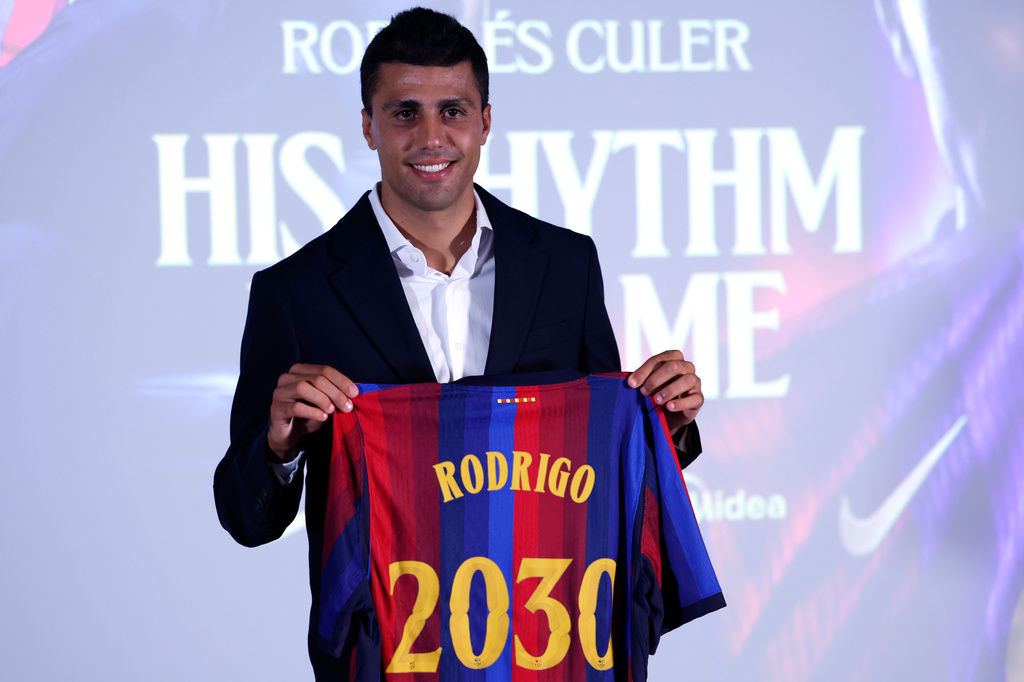 Barcelona's Rodri poses with his jersey during his official presentation at a soccer press conference in Barcelona, Spain, Tuesday, Aug. 18, 2026. (AP Photo/Joan Monfort)