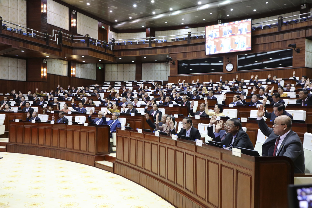 In this photo released by the Cambodia National Assembly, Cambodian lawmakers raise their hands during the session on the draft law on amending the law on nationality at the National Assembly in Phnom Penh, Cambodia, Monday, Aug. 25, 2025. (Cambodia National Assembly via AP)