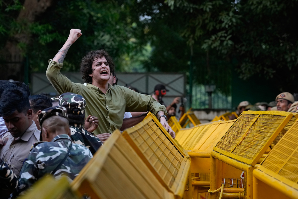A protester shouts slogans as he climbs onto a police barricade during a march by opposition parties toward the Supreme Court demanding the resignation of Chief Election Commissioner Gyanesh Kumar in New Delhi, India, Monday, Oct. 12, 2026. (AP Photo/Manish Swarup)