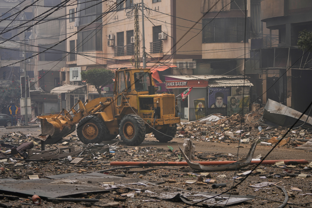 A bulldozer clears debris from the rubble of buildings destroyed in an Israeli airstrike in Dahiyeh, Beirut's southern suburbs, Lebanon, Sunday, March 15, 2026. (AP Photo/Hassan Ammar)